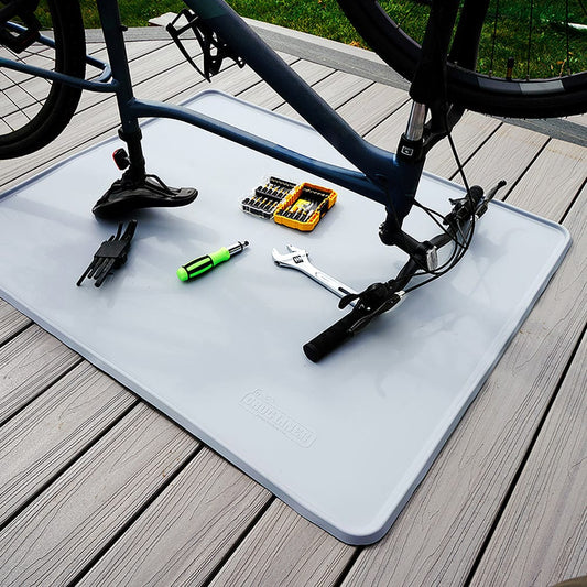 Everything Mat® Multi-Purpose Rubber Floor Mat outside with tools and an upside down bike on top