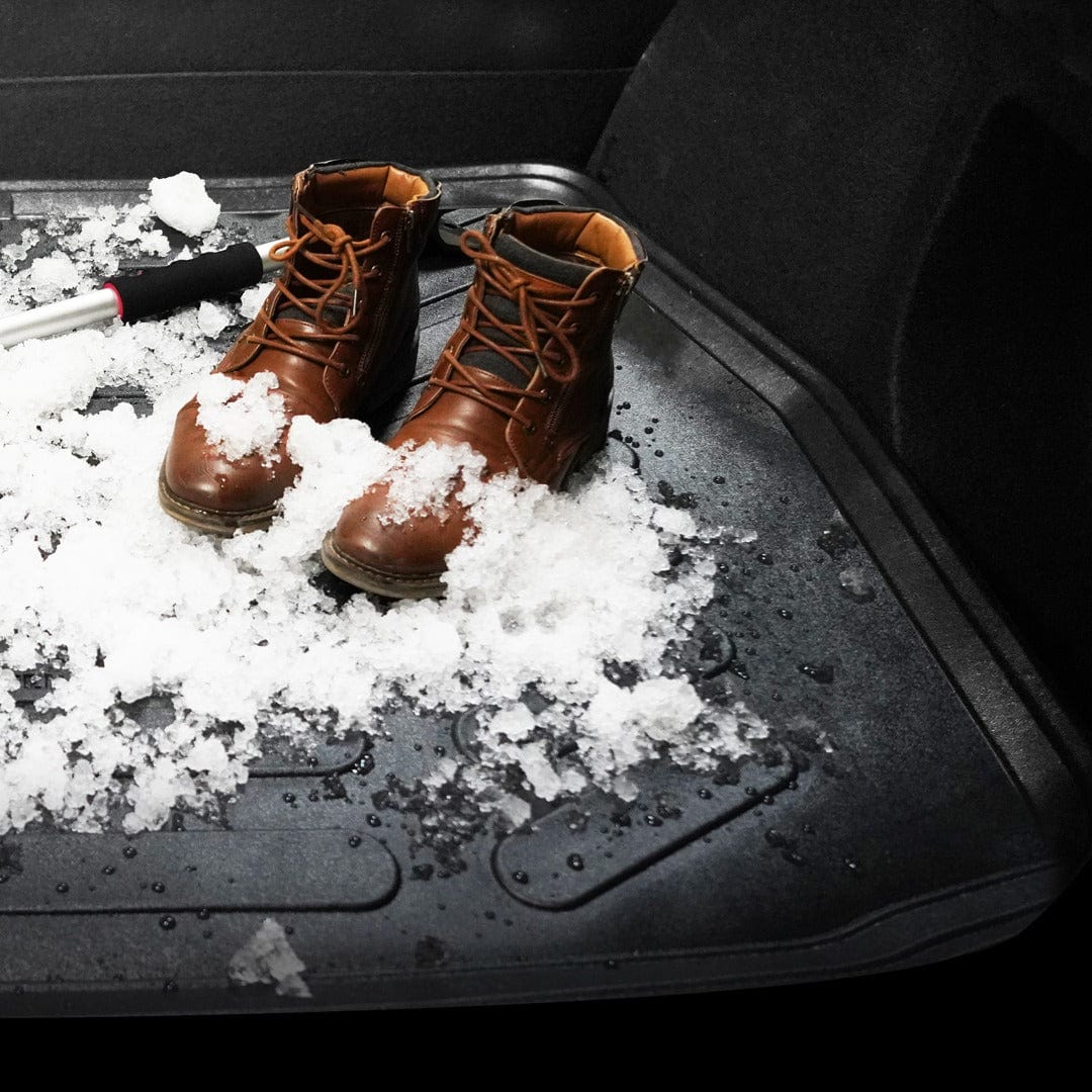 Cargo Liner covered in snow with boots sitting in the snow.